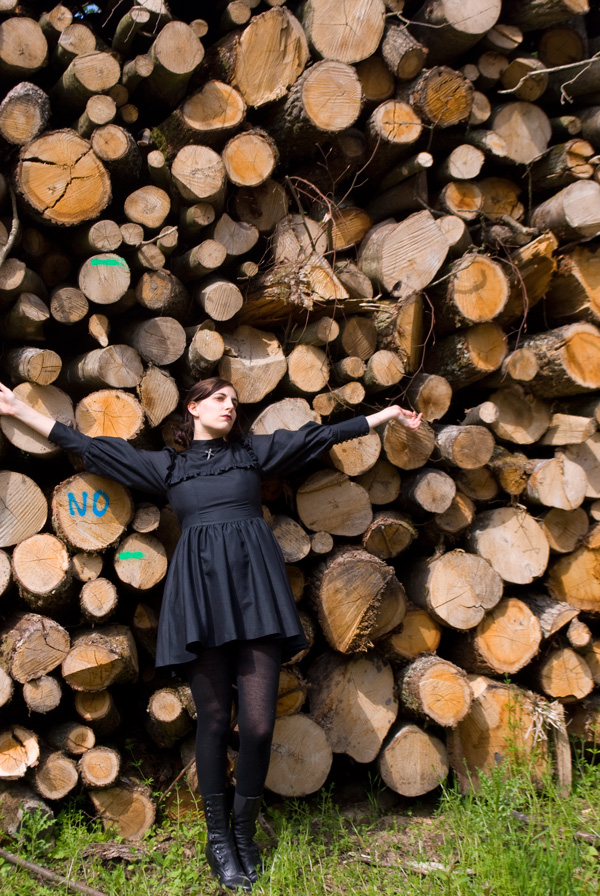 Wearing Moi-Même-Moitié nun dress in front of a pile of wood