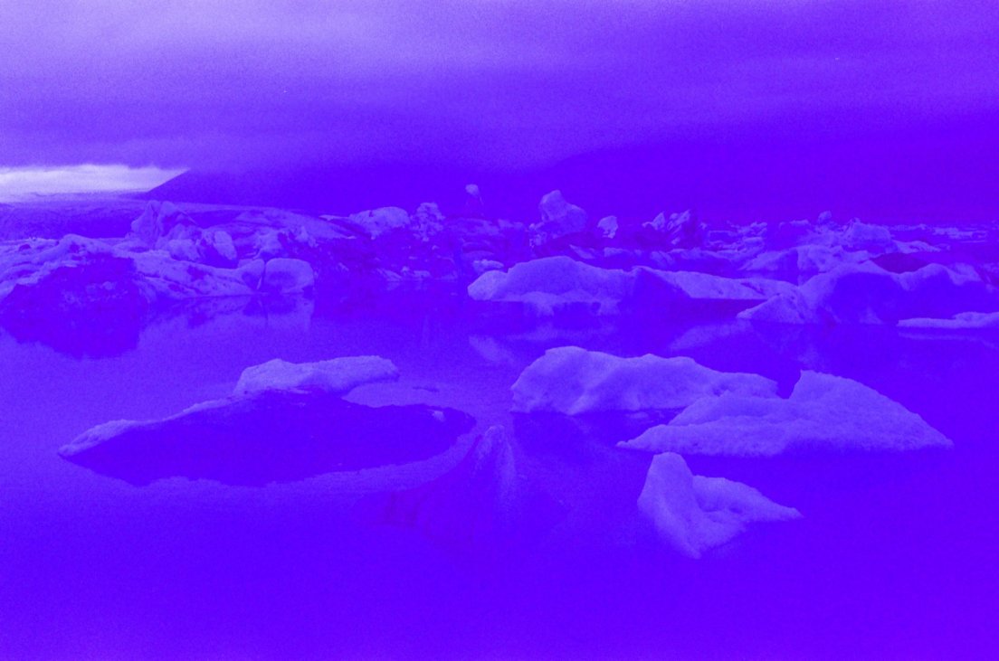 Heavily blue-tinted photograph of icebergs