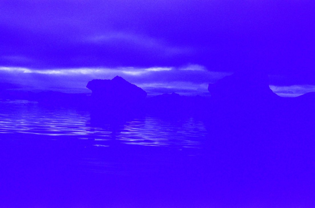 Heavily blue-tinted photograph of icebergs