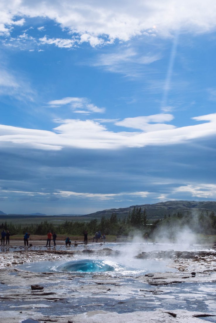 Early stage of the Strokkur eruption with a turquoise bubble about to burst out