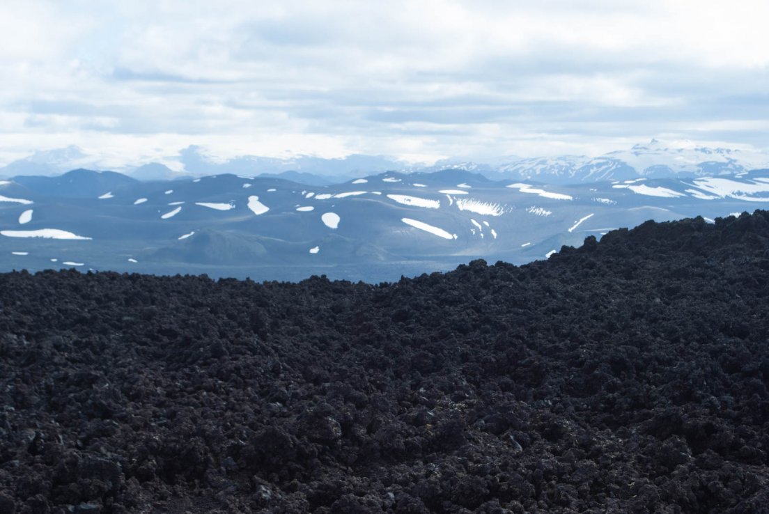 Lava field and snow-capped moutains on a sunny day