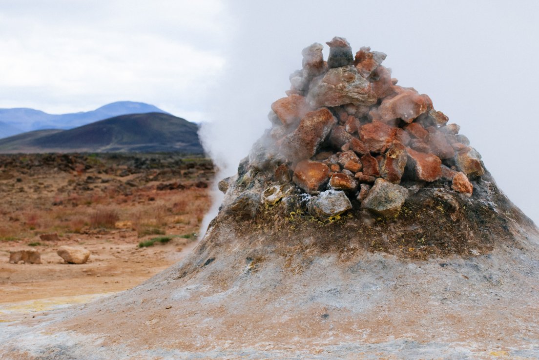 Fuming tall crater on a desert background