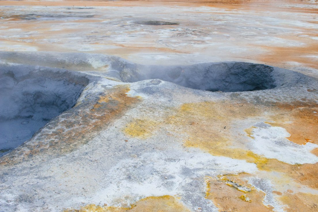 Black mud and orange ground in an area of volcanic activity