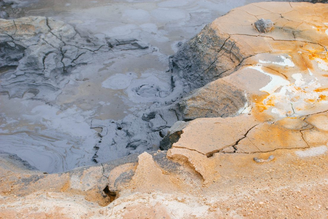 Crumpling orange ground giving way to bubbling black mud