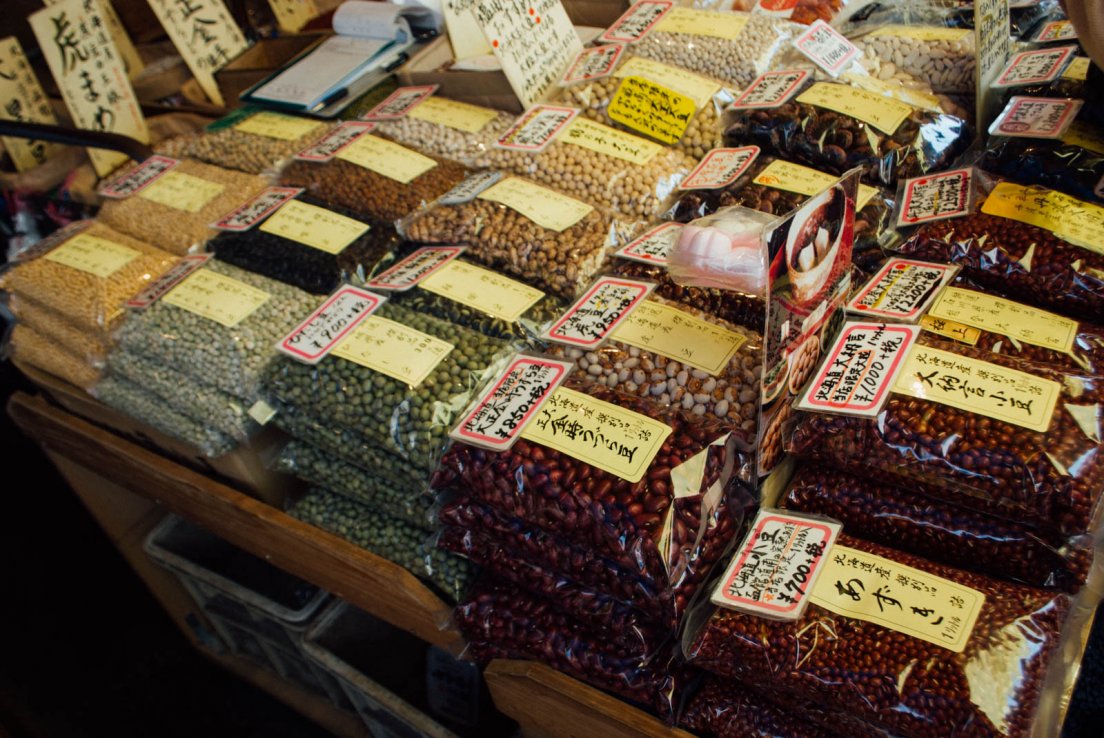A food stall displaying various beans such as azuki beans