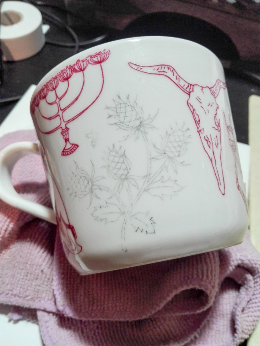 Example of a later discarded drawing, the skull, on a cardinal red teacup for Enchanteresse, a collection of hand-painted porcelains by messalyn