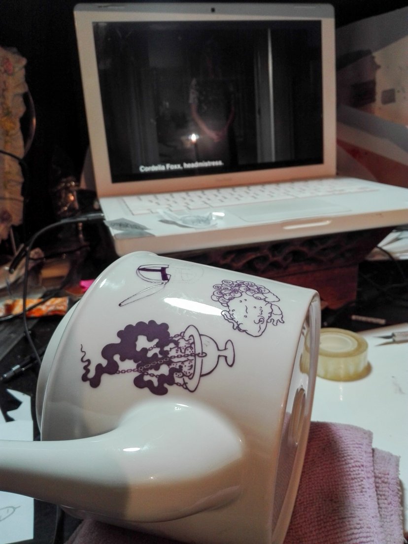 Work in progress of a purple teapot from Enchanteresse, a hand-painted porcelain collection by messalyn, in front of the tv show American Horror Story: Coven, 15 march 2019 Work in progress of a purple teapot from Enchanteresse, a hand-painted porcelain collection by messalyn, in front of the tv show American Horror Story: Coven