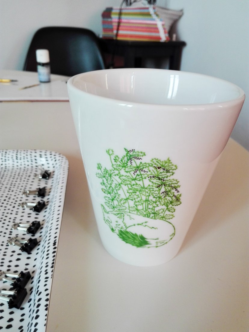 Painting in true matte gold the nettles seeds in the green Renard mug from Enchanteresse, a collection of hand-painted porcelains by messalyn