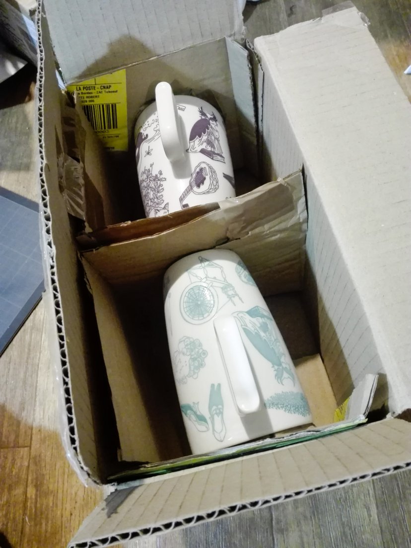 Purple and seafoam mugs from Enchanteresse, a hand-painted porcelain collection by messalyn, fixed in their box for transport